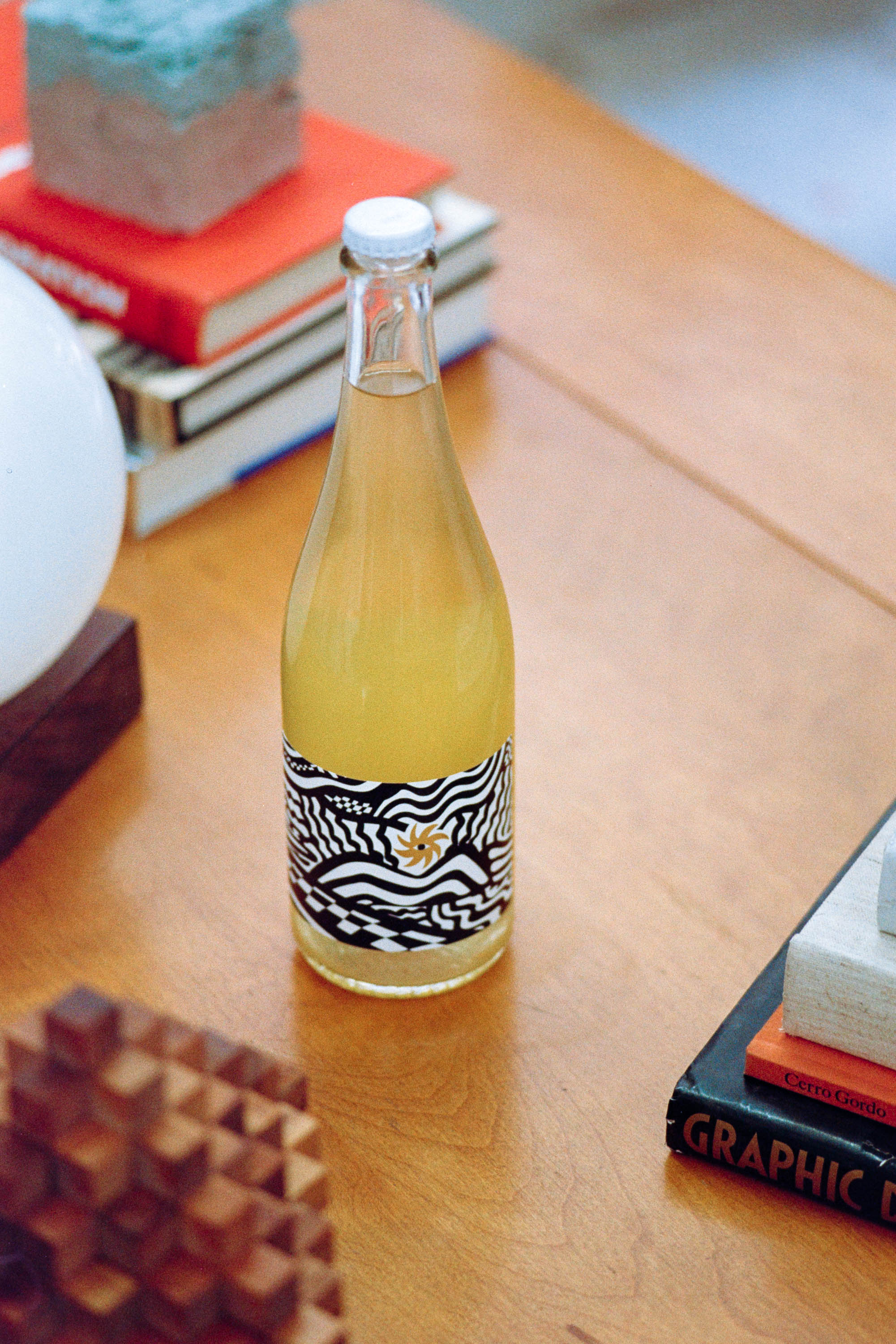 Picture of Super Natura Bianco by Loose Wines on a coffee table with books